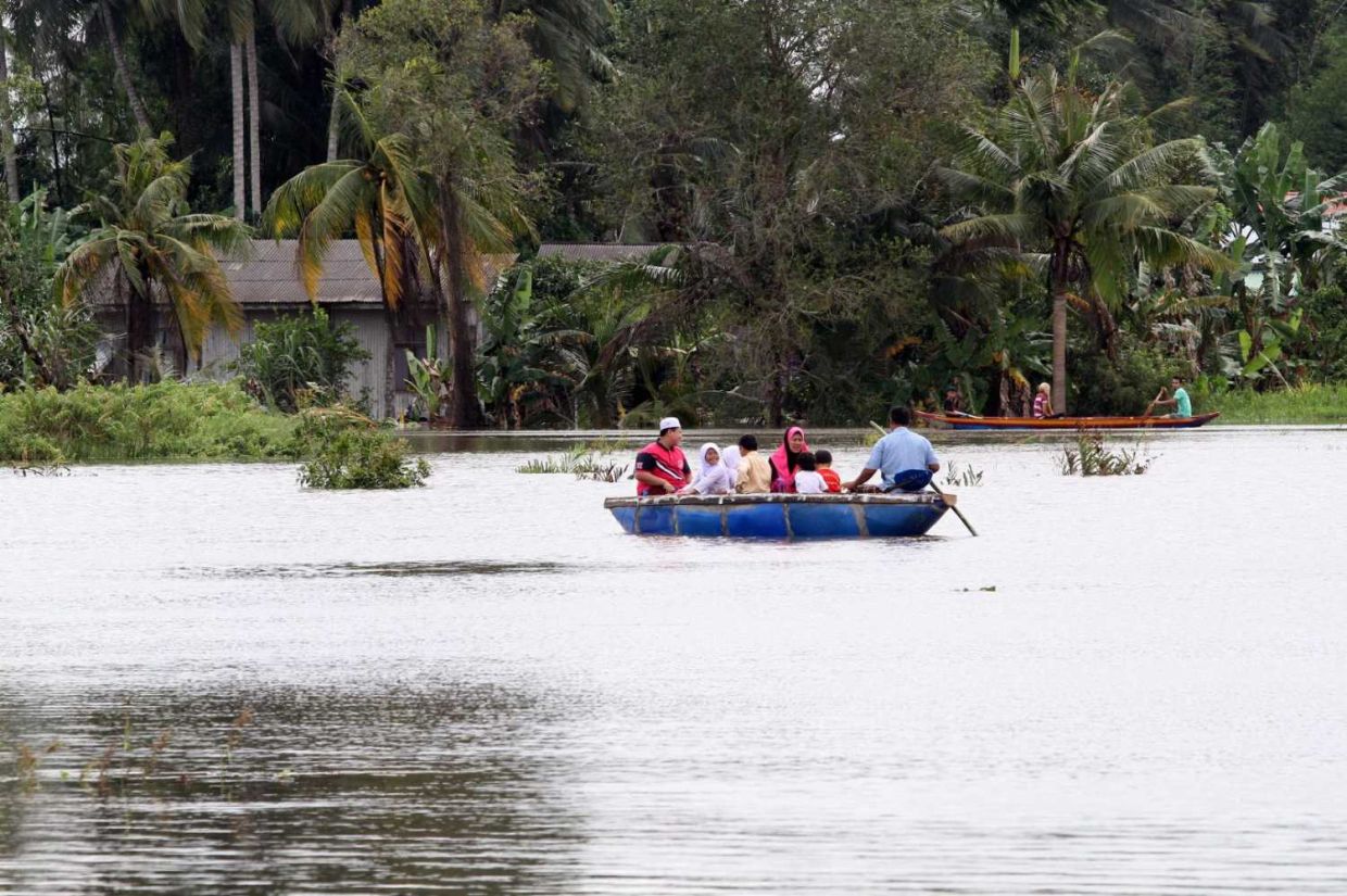 Families at Kampung Talak in Tumpat, Kelantan being evacuated by boat as flood waters rise in their area.